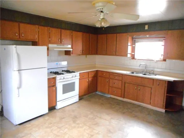 a kitchen with a white stove cabinets and a refrigerator