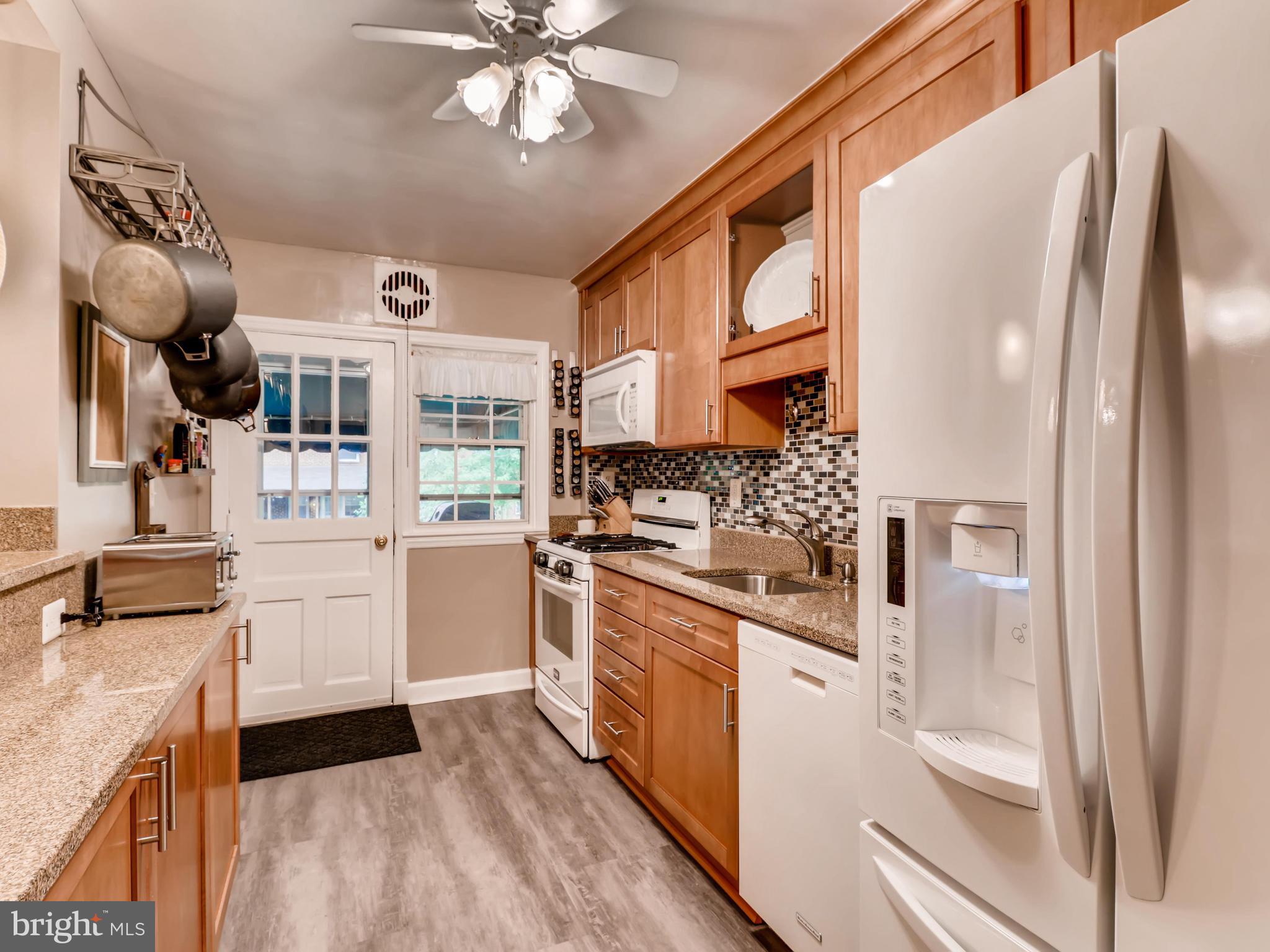 427 Stratford Road Baltimore, MD 21228 - Photo 11 of 29 a kitchen with stainless steel appliances a white stove top oven and a refrigerator