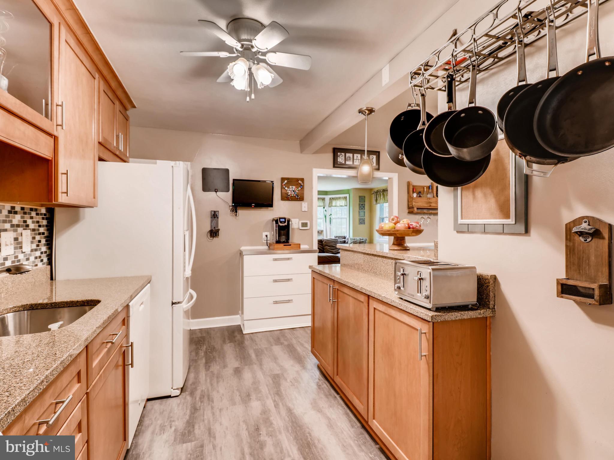 427 Stratford Road Baltimore, MD 21228 - Photo 13 of 29 a kitchen with stainless steel appliances granite countertop a sink a stove a refrigerator cabinets a dining table and chairs