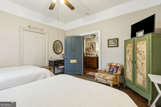 a spacious bedroom with a bed a chandelier and a dresser