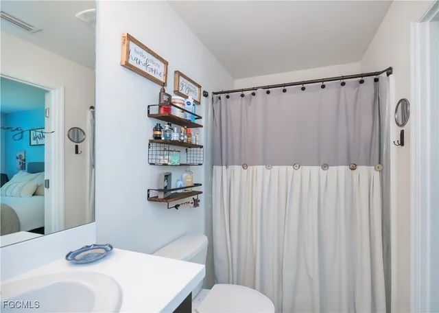 a bathroom with a sink a toilet and shower curtain