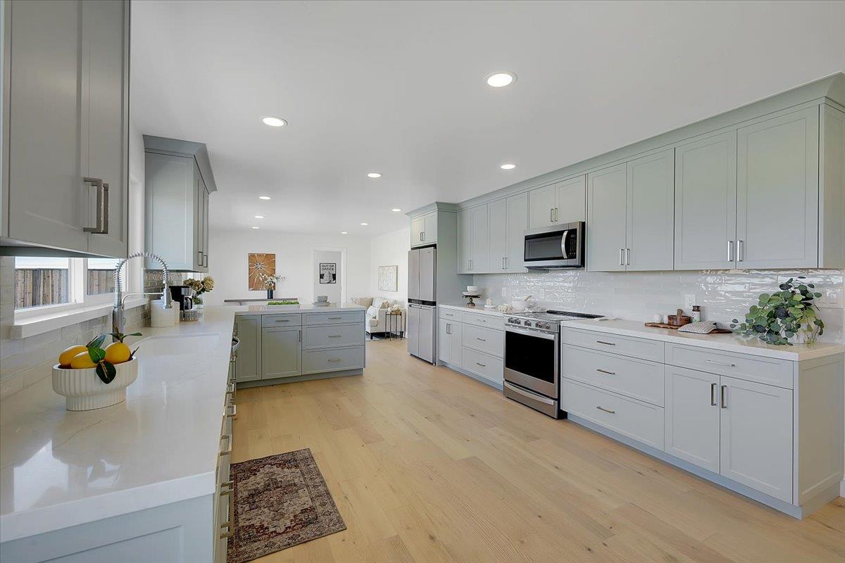1181 Barry Road Yuba City, CA 95991 - Photo 15 of 60 a large white kitchen with white cabinets and stainless steel appliances