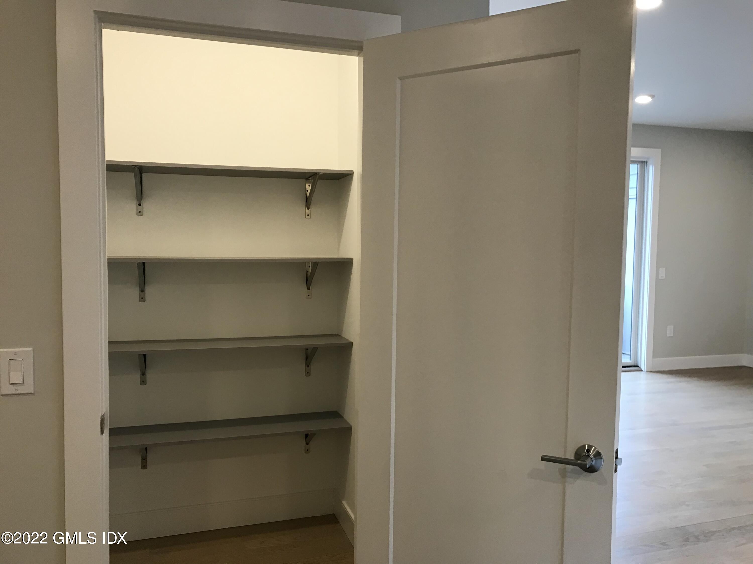 56 Old Field Point Road, Unit 1 Greenwich, CT 06830 - Photo 9 of 30 a view of walk in closet with empty racks