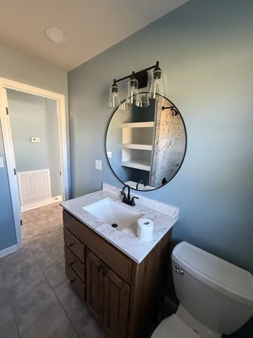 a bathroom with a toilet a sink and mirror