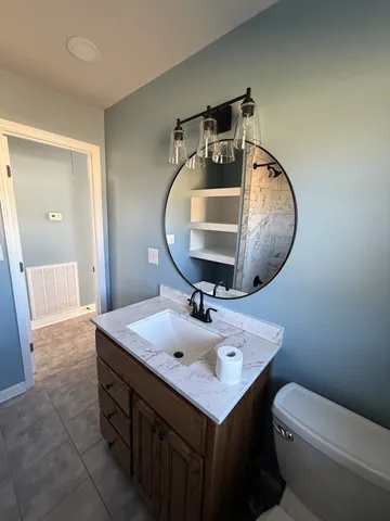 a bathroom with a sink mirror and toilet
