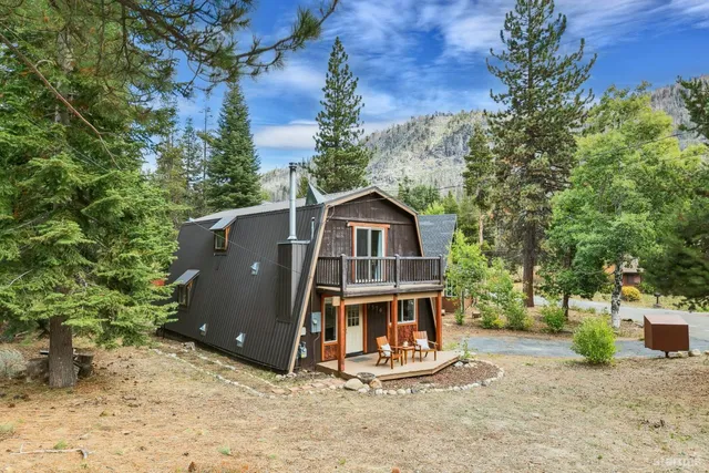 a small barn with a small yard and large trees