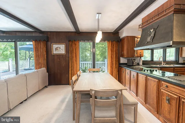 a large kitchen with stainless steel appliances granite countertop a large stove a sink dishwasher a refrigerator and white cabinets with wooden floor