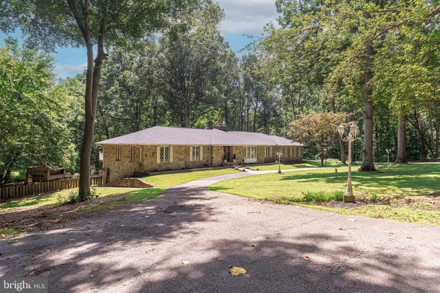 a view of a house with backyard and trees