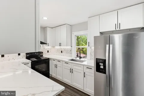 a kitchen with stainless steel appliances a refrigerator sink and cabinets