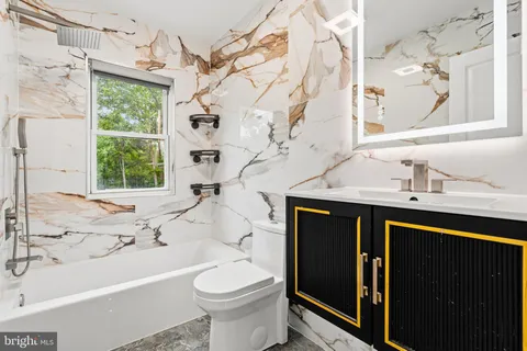 a bathroom with a sink a toilet and bathtub