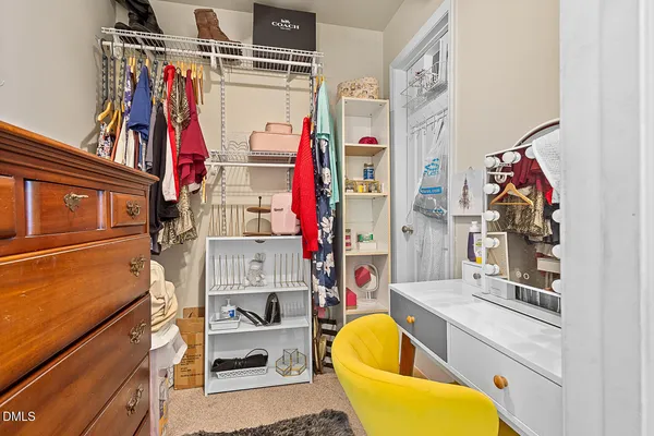 a view of walk in closet with clothes and shoes