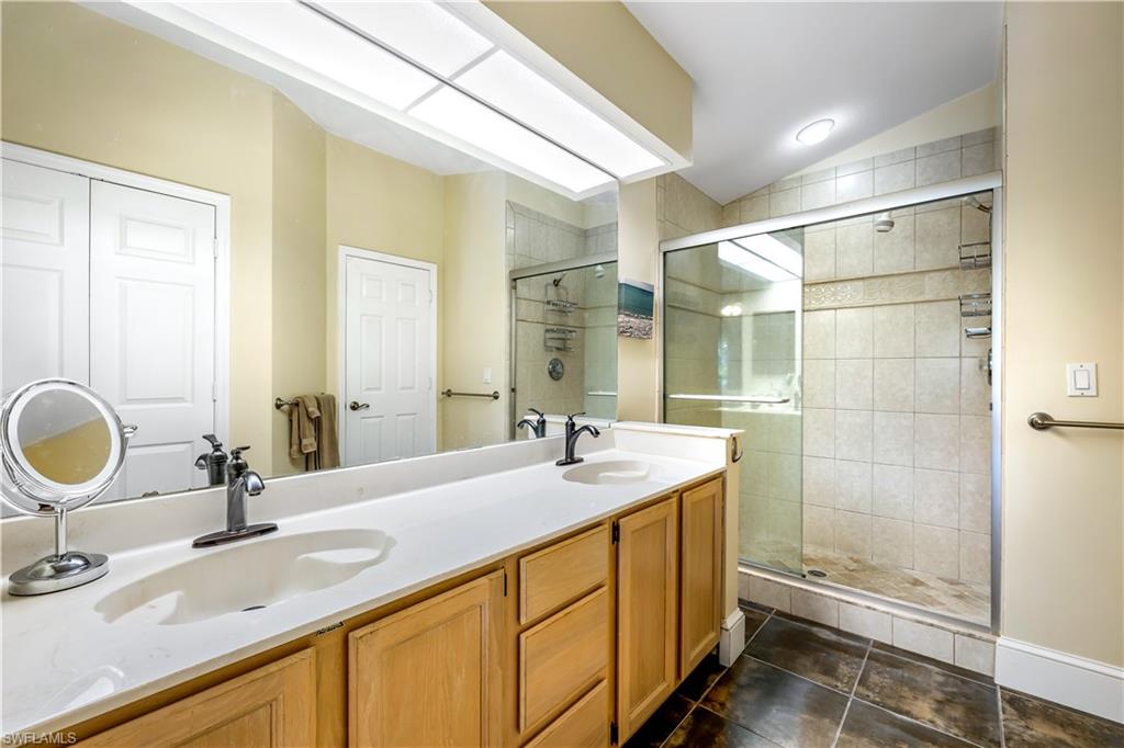 1350 Misty Pines Circle, Unit 204 Naples, FL 34105 - Photo 13 of 19 a bathroom with a granite countertop sink a mirror and shower