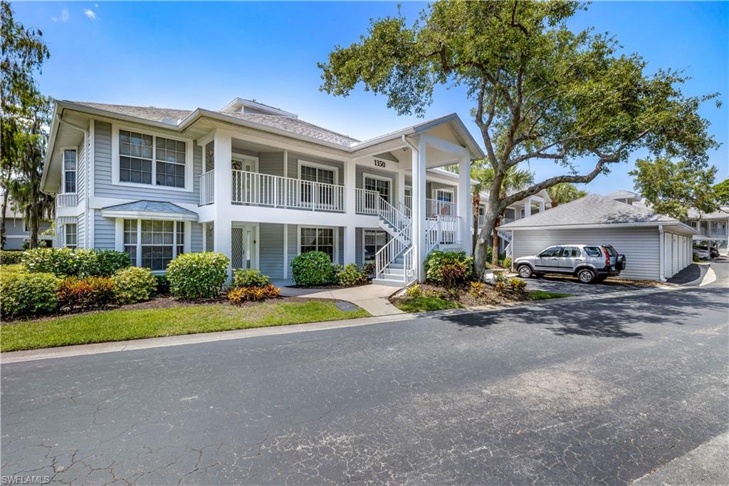 1350 Misty Pines Circle, Unit 204 Naples, FL 34105 - Photo 2 of 19 a front view of a house with a yard and potted plants
