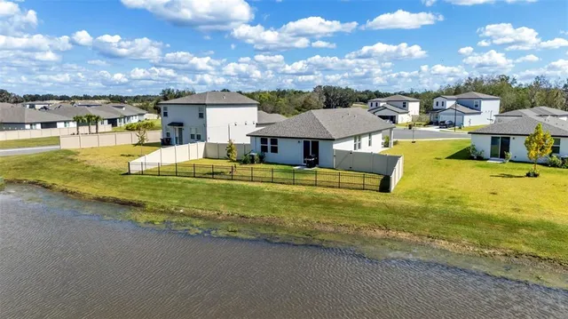 an aerial view of a house with swimming pool and outdoor seating