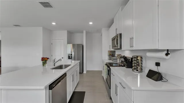 a kitchen with white cabinets and stainless steel appliances