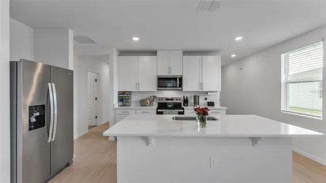a metallic refrigerator freezer sitting in a kitchen