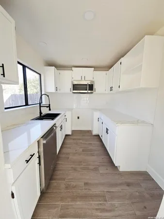 a kitchen with granite countertop a sink and cabinets