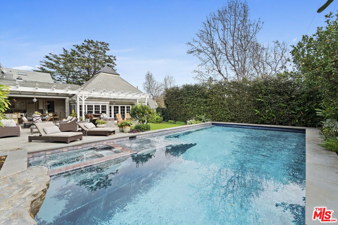 342 10th Street Santa Monica, CA 90402 - Photo 51 of 53 a view of a house with pool and chairs under an umbrella