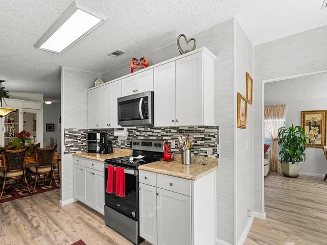 a kitchen with microwave a stove and cabinets