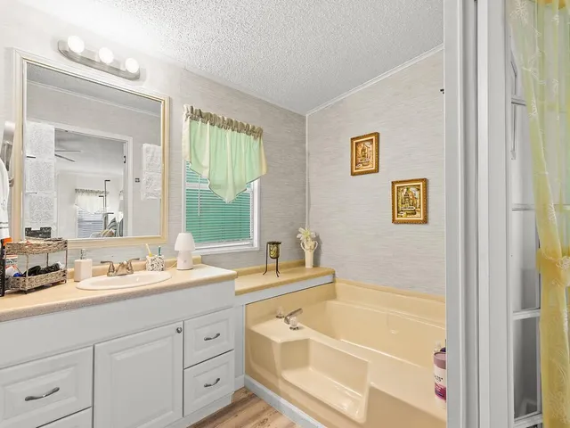 a bathroom with a tub sink and mirror