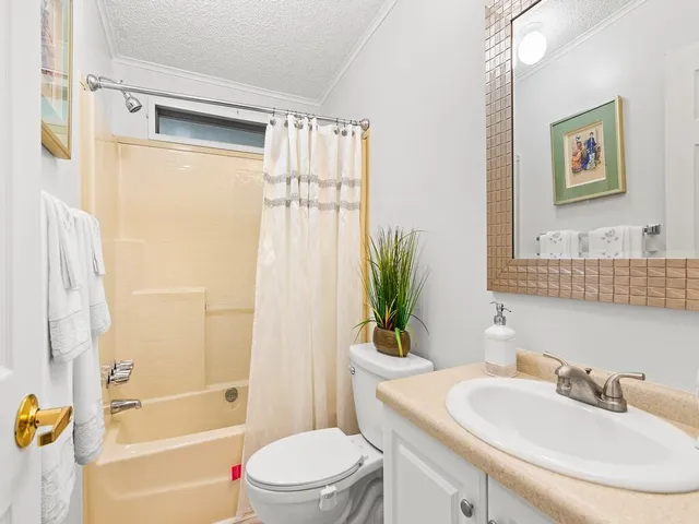 a bathroom with a sink a toilet a tub and shower