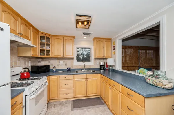 a spacious kitchen with stainless steel appliances granite countertop a sink dishwasher stove and cabinets with wooden floor
