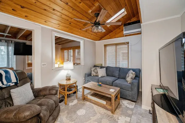 a living room with furniture a ceiling fan and a window