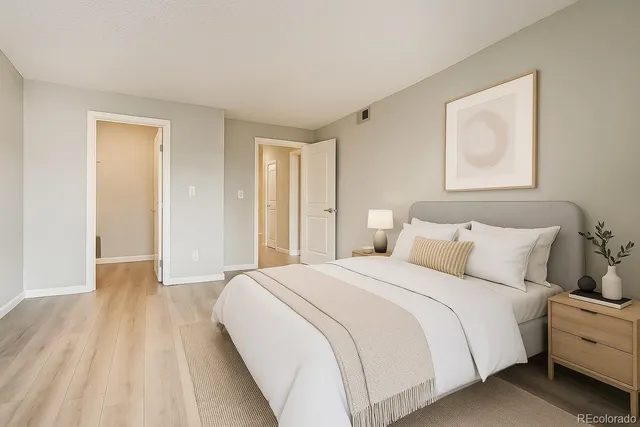 a spacious bedroom with a bed and a painting on the wall