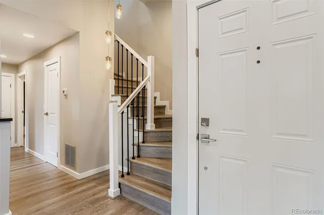 a view of a hallway with wooden floor and entryway