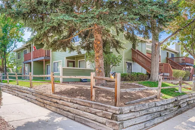 a view of a house with a yard and large tree