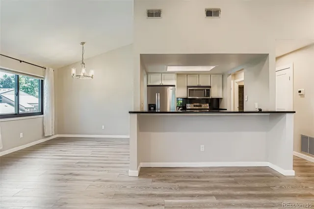 a view of a kitchen with furniture and wooden floor