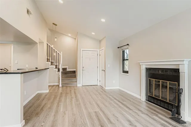 a view of a hallway with wooden floor and a fireplace