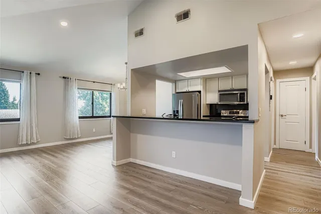 a view of kitchen with stainless steel appliances refrigerator sink and cabinets