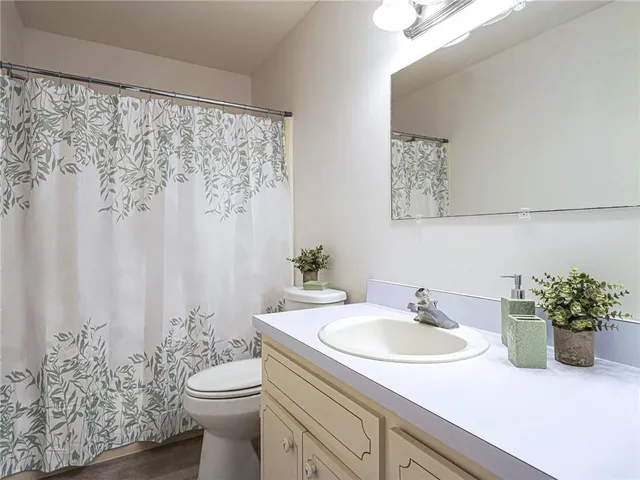 a bathroom with a sink a toilet and a mirror
