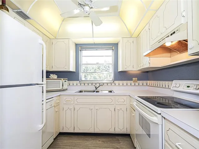 a kitchen with white cabinets sink and white appliances
