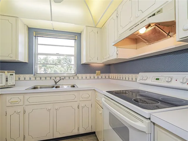 a kitchen with a sink cabinets and window