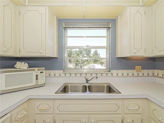 a kitchen with a sink cabinets and window