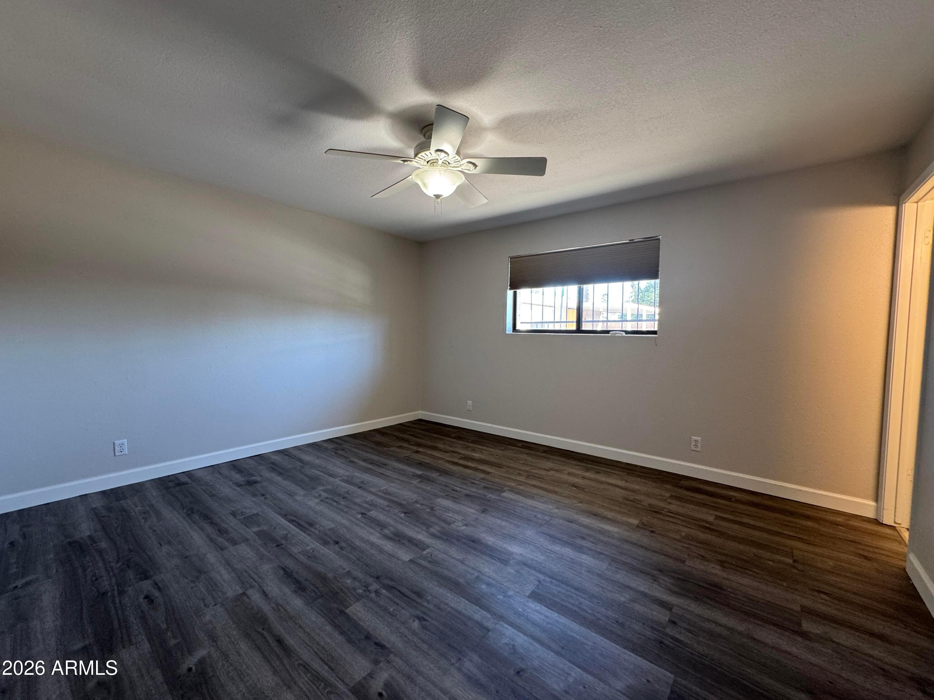 6317 East McLellan Road Mesa, AZ 85205 - Photo 13 of 28 an empty room with wooden floor and windows