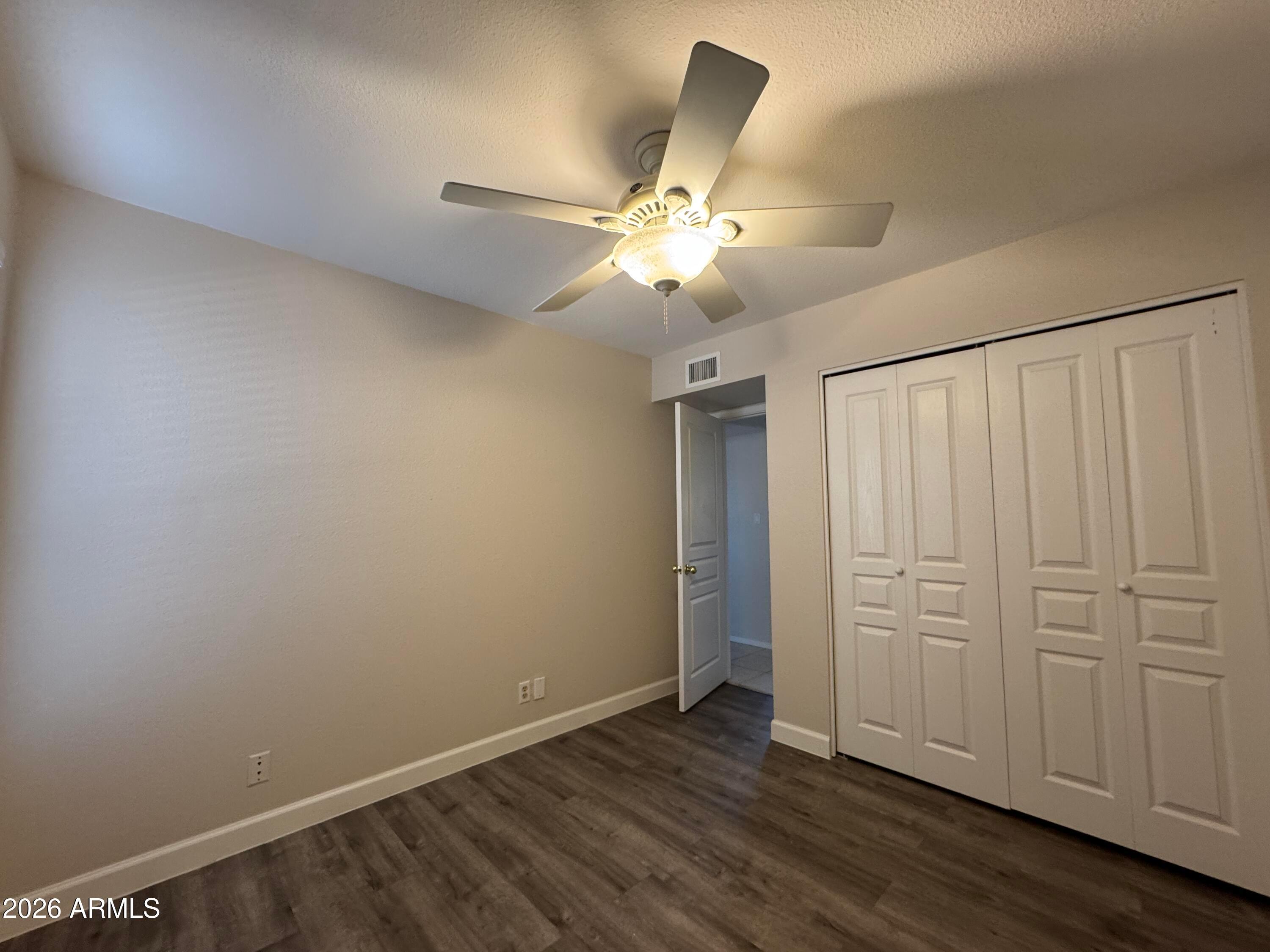6317 East McLellan Road Mesa, AZ 85205 - Photo 16 of 28 an empty room with wooden floor fan and windows