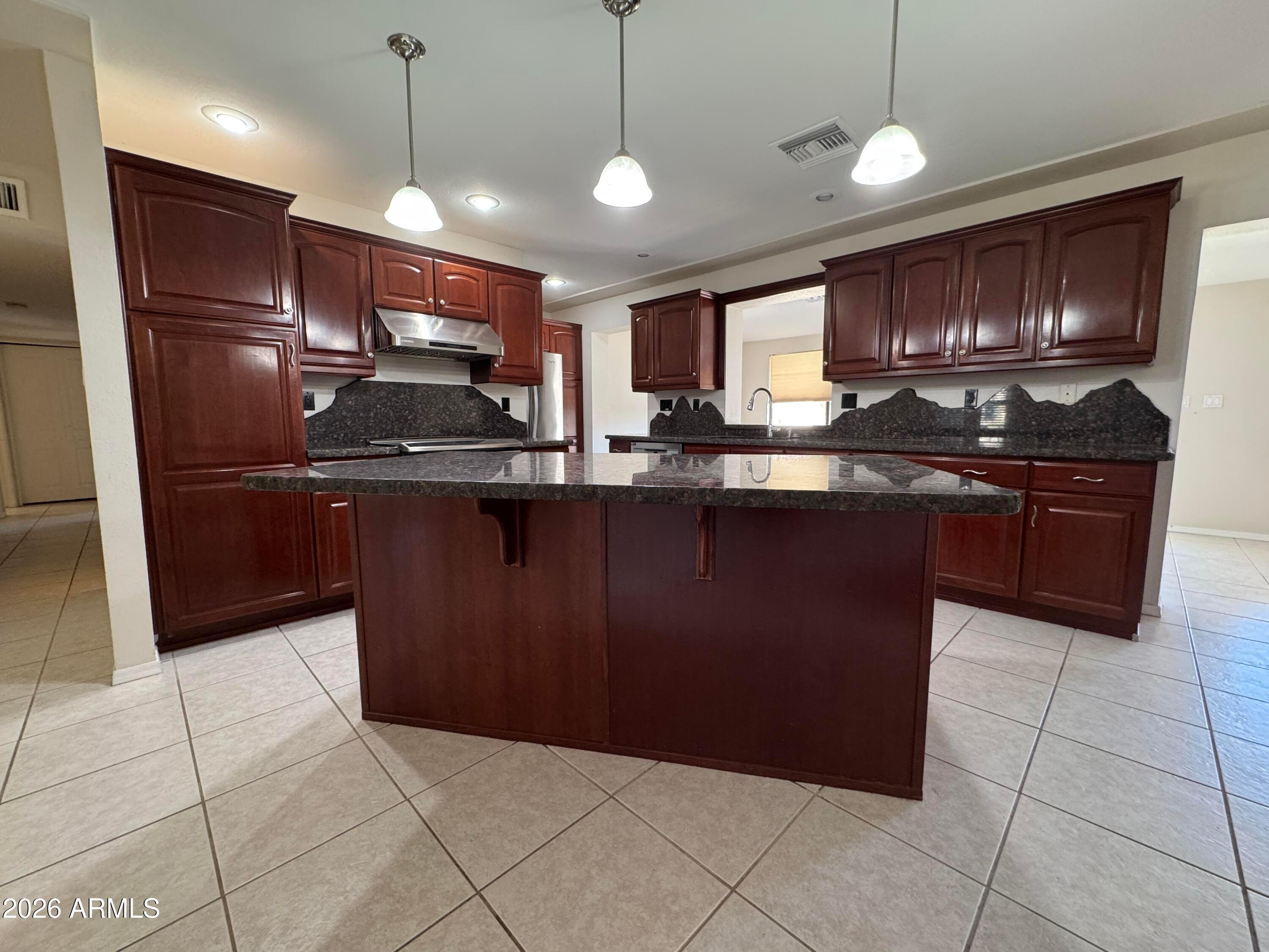 6317 East McLellan Road Mesa, AZ 85205 - Photo 7 of 28 a kitchen with stainless steel appliances granite countertop a sink and a refrigerator