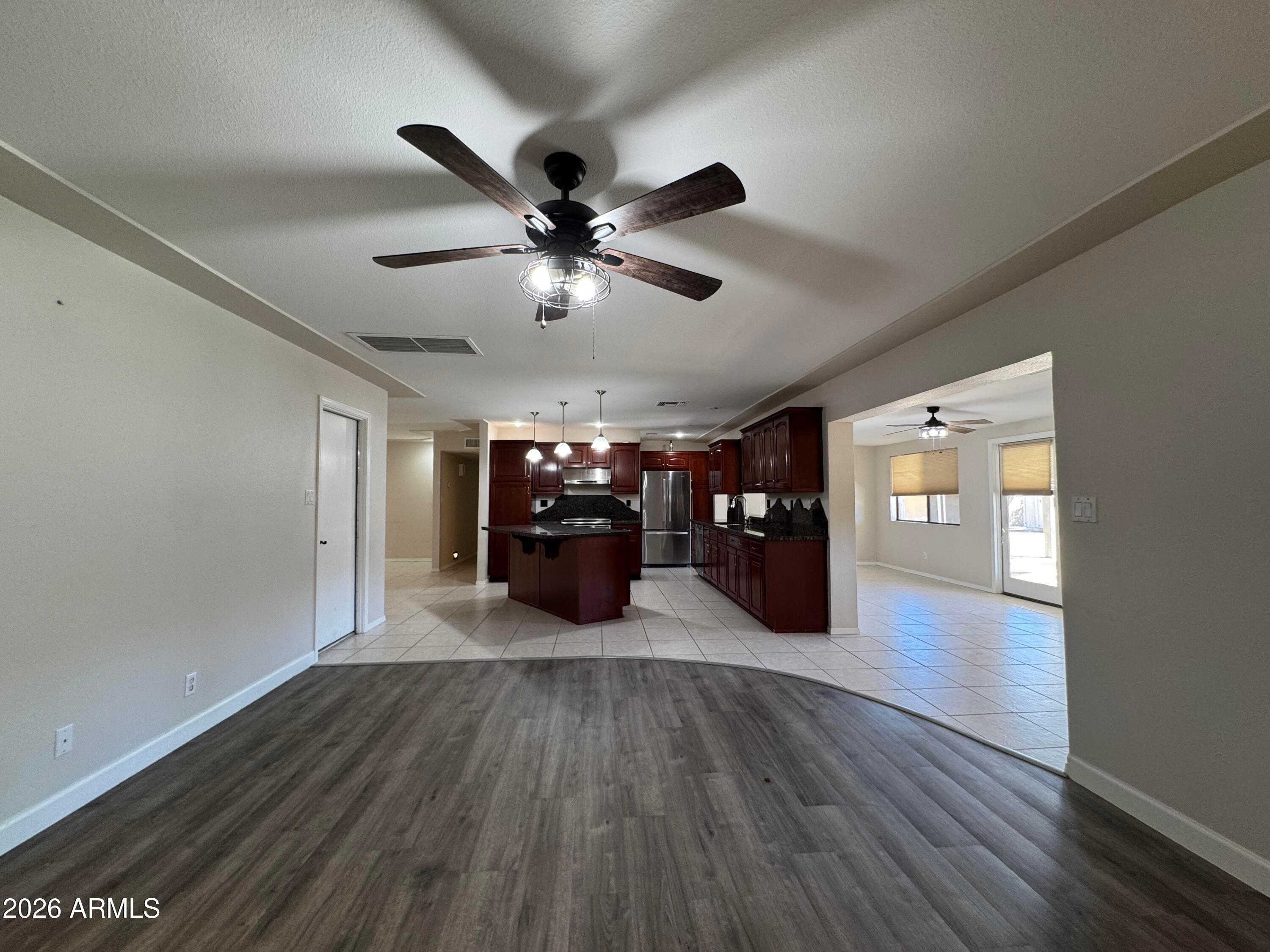 6317 East McLellan Road Mesa, AZ 85205 - Photo 8 of 28 a big room with wooden floor chandelier and a ceiling fan