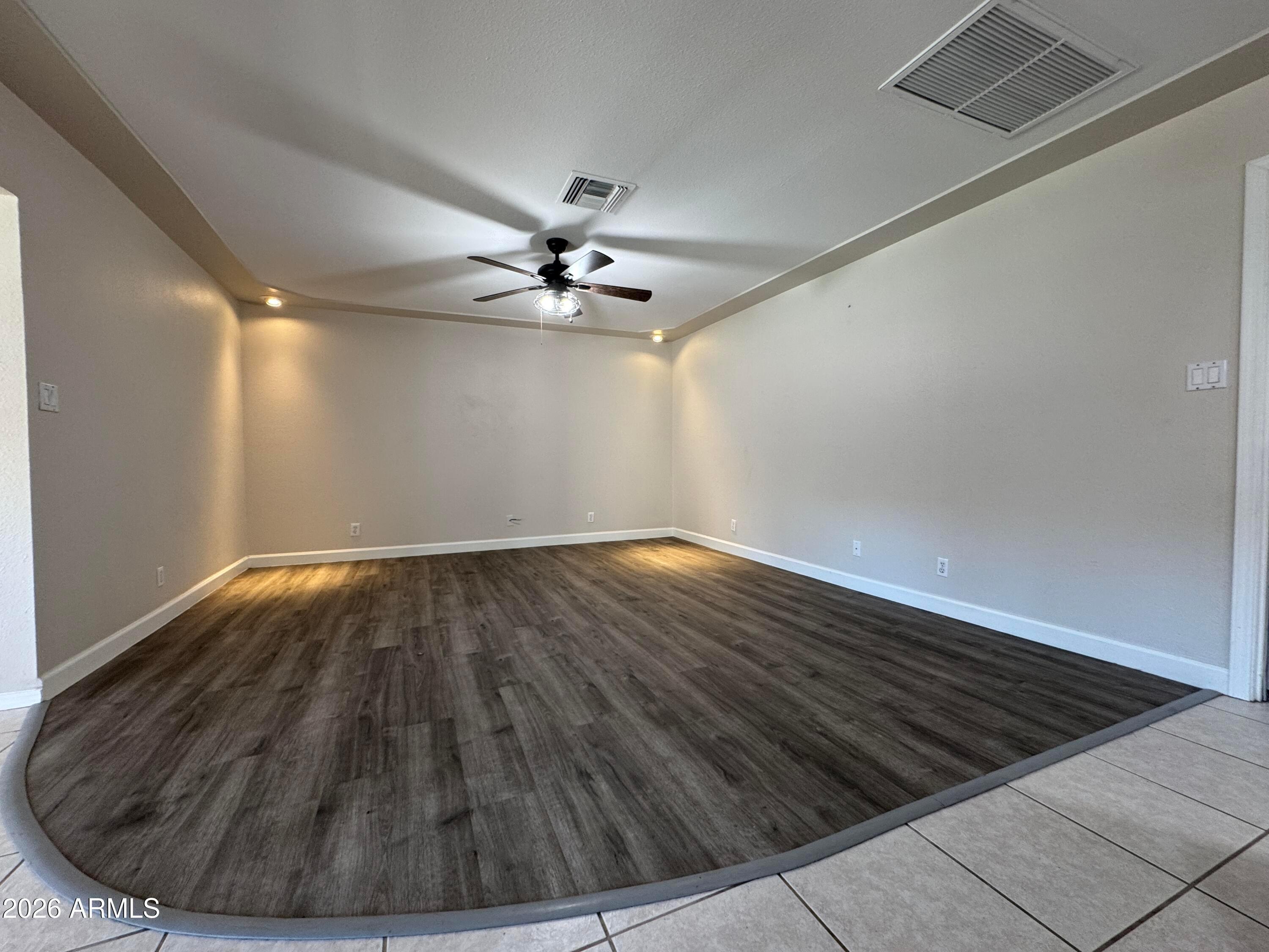 6317 East McLellan Road Mesa, AZ 85205 - Photo 9 of 28 a view of an empty room with wooden floor and a ceiling fan
