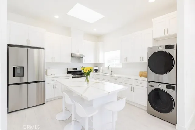 a kitchen with a sink a stove cabinets and stainless steel appliances