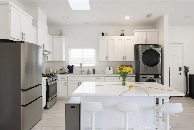 a kitchen with kitchen island a sink refrigerator and cabinets
