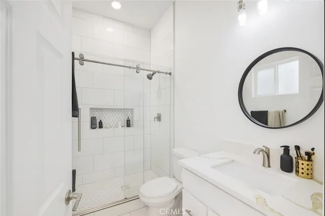 a bathroom with a sink a toilet and a mirror