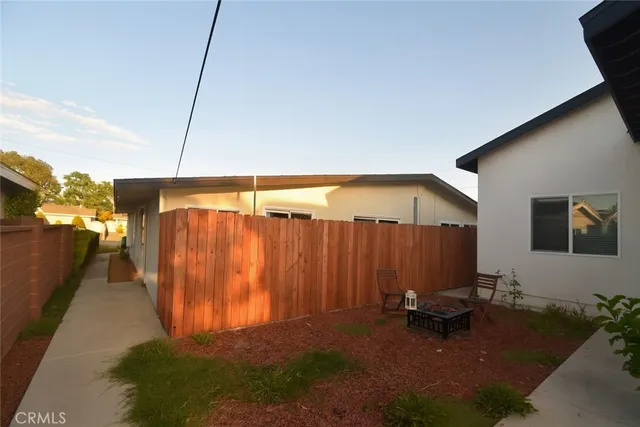 a backyard of a house with a table and chairs