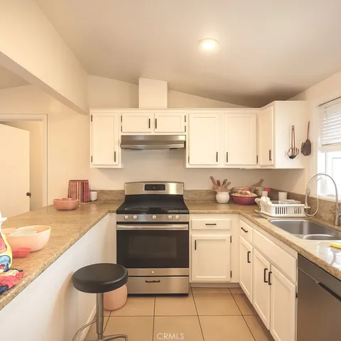 a kitchen with a stove sink and cabinets