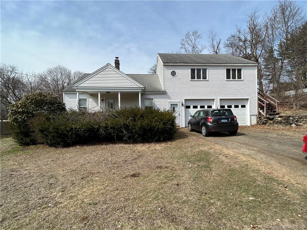 a front view of a house with cars parked