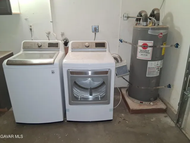 a utility room with cabinets washer and dryer