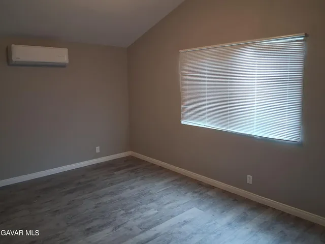 an empty room with wooden floor and a window